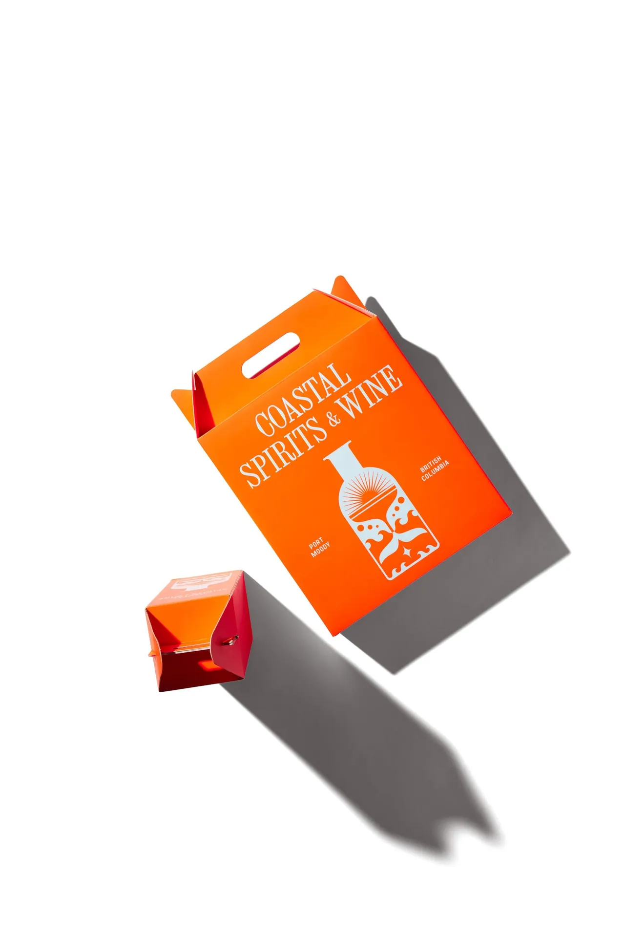 An orange Coastal Spirits & Wine gift box with a small matching box beside it